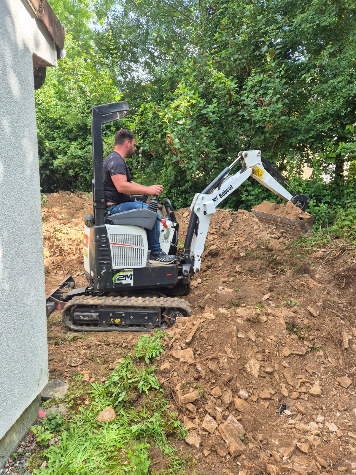 Hermano aux commandes d'une mini-pelle sur un chantier de terrassement