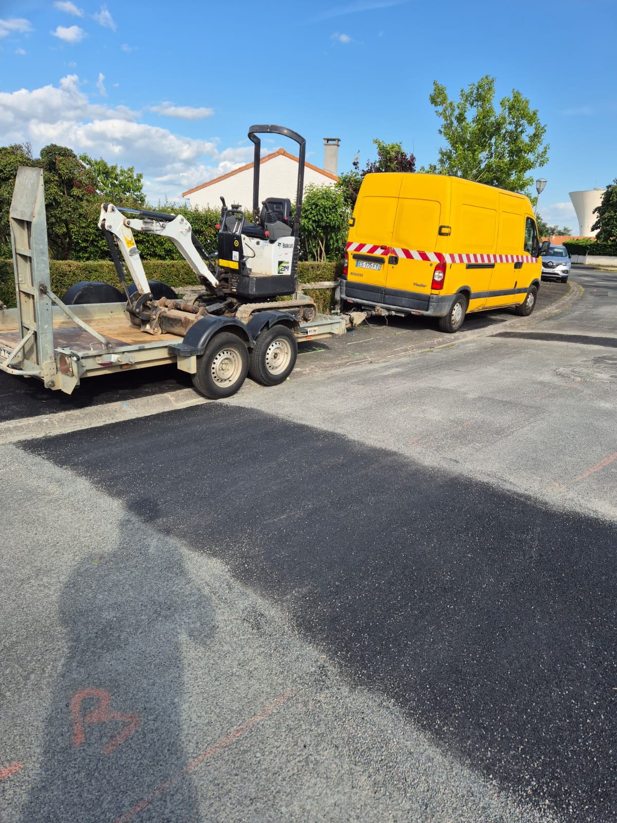 Fourgon avec remorque transportant une mini-pelle vers un chantier